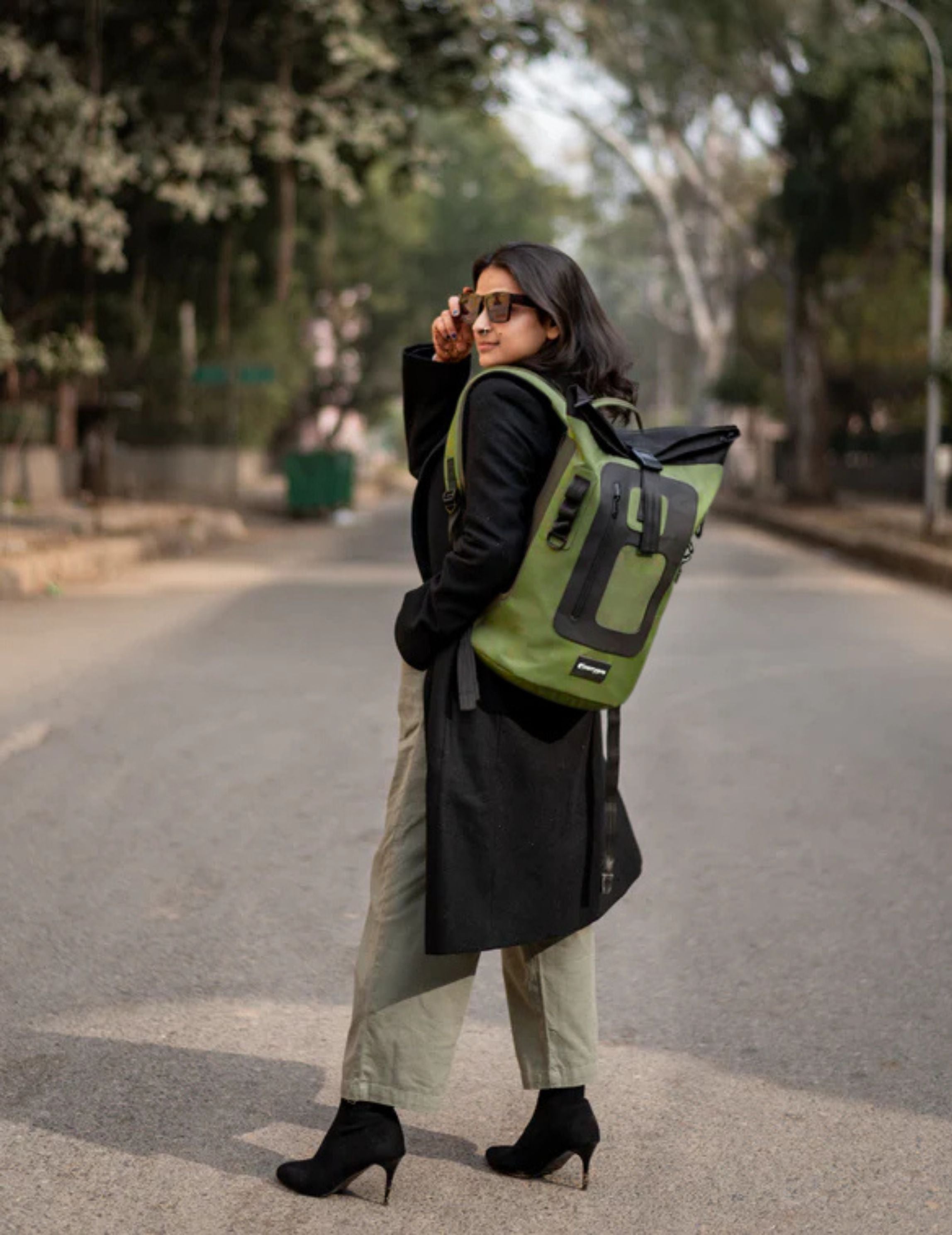 Person walking with CarryPro roll-top backpack in a heritage setting
#color_Olive Green